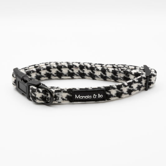 The Classic Houndstooth Collar & Lead features a black and white houndstooth adjustable collar with a black plastic buckle and Manala & bo label, shown on a white background.
