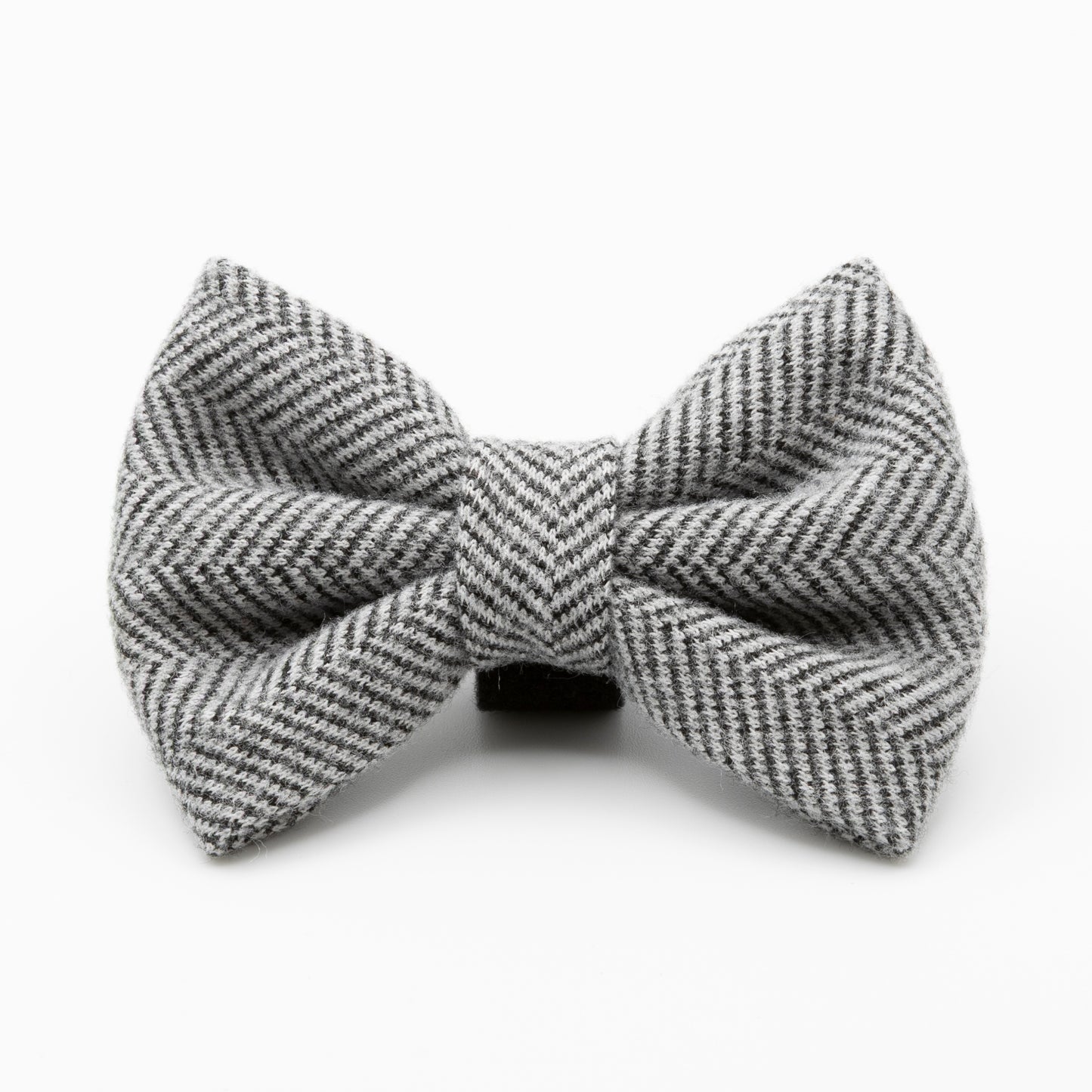 The Monochrome Tweed Dog Bow Tie, featuring a gray and white herringbone pattern, is displayed against a plain white background to highlight its classic tweed texture and stylish design.