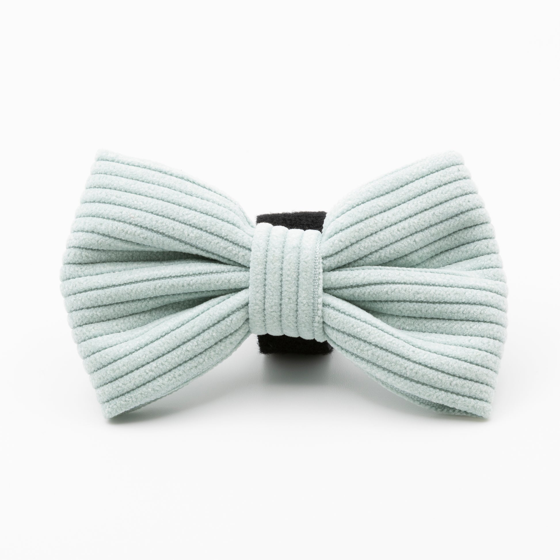 The Aqua Cord Dog Bow Tie, made of light blue ribbed fabric with a black center band, is a stylish and durable accessory for your dog, shown against a white background.