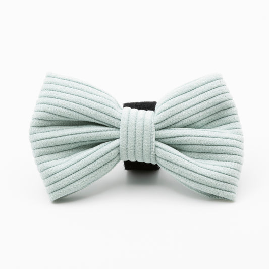 The Aqua Cord Dog Bow Tie, made of light blue ribbed fabric with a black center band, is a stylish and durable accessory for your dog, shown against a white background.