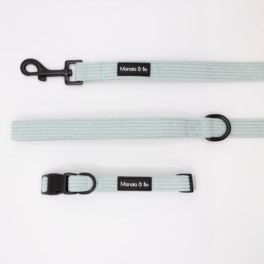 The Aqua Cord Collar & Lead set features a pale blue adjustable collar and matching leash with black hardware and Manola & bo label, designed for small to medium dogs. Shown on a white background for comfortable fit and stylish look.