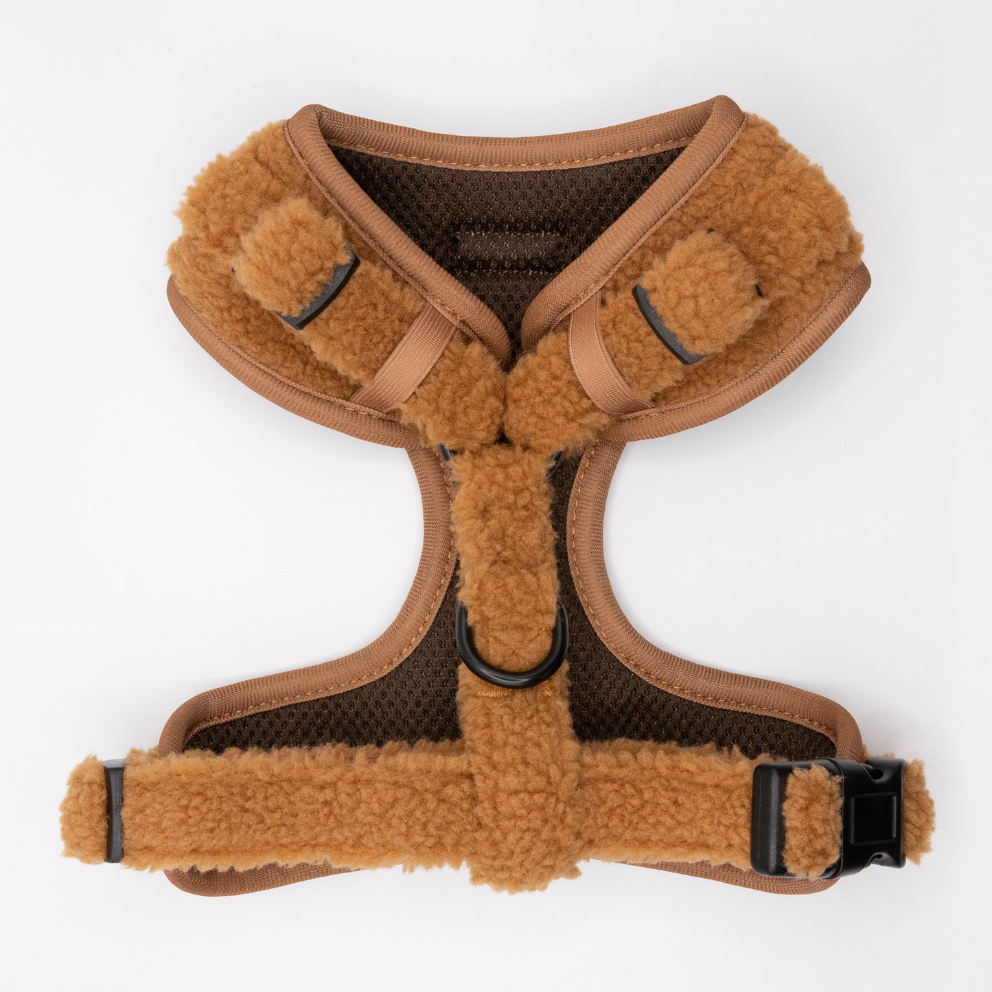 The Caramel Teddy Harness & Lead is a brown and tan fleece-lined adjustable harness with black mesh lining, two black plastic buckles, and a central metal leash ring, shown on a white background.