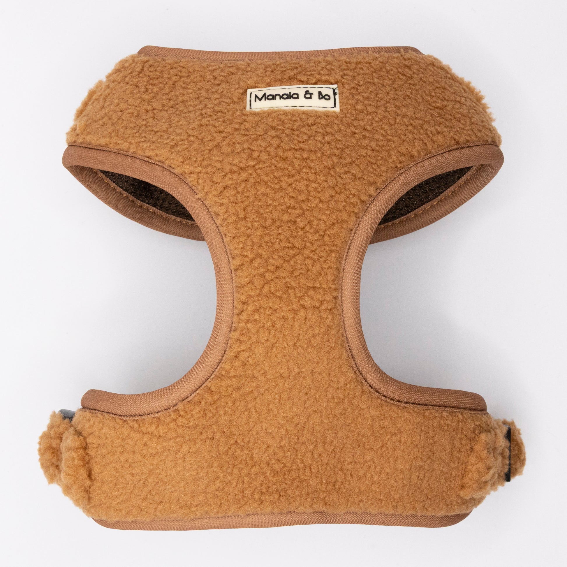 The Caramel Teddy Harness & Lead is a tan, fleece-lined, adjustable dog harness with brown edging and a Monala & bo label on the front, shown against a white background.