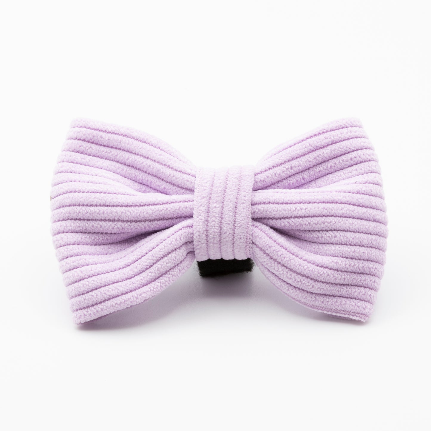 The Lavender Cord Dog Bow Tie is a ribbed, pastel purple accessory featuring a black clip on the back, shown against a white background.