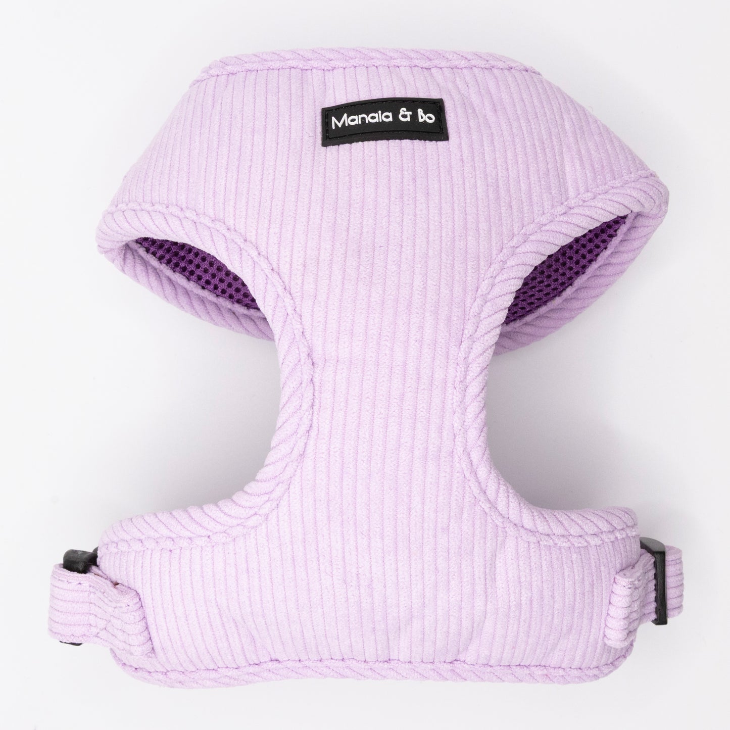 The Lavender Cord Harness & Lead features a light purple, ribbed harness with black plastic buckles and a Manala & Bo label on the front, shown on a white background. Perfectly pairs with the matching pastel purple lead.