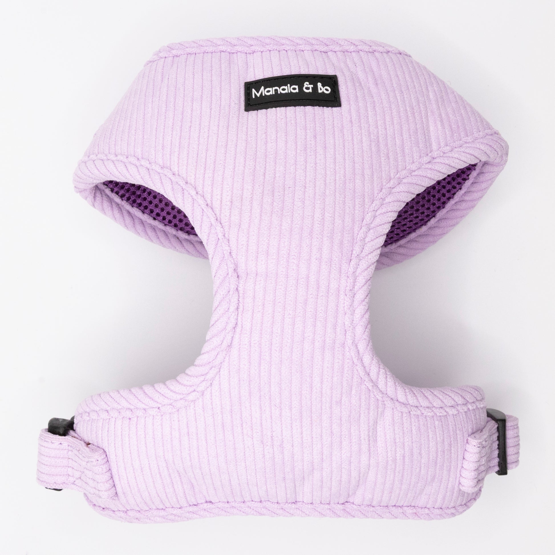 The Lavender Cord Harness & Lead features a light purple, ribbed harness with black plastic buckles and a Manala & Bo label on the front, shown on a white background. Perfectly pairs with the matching pastel purple lead.