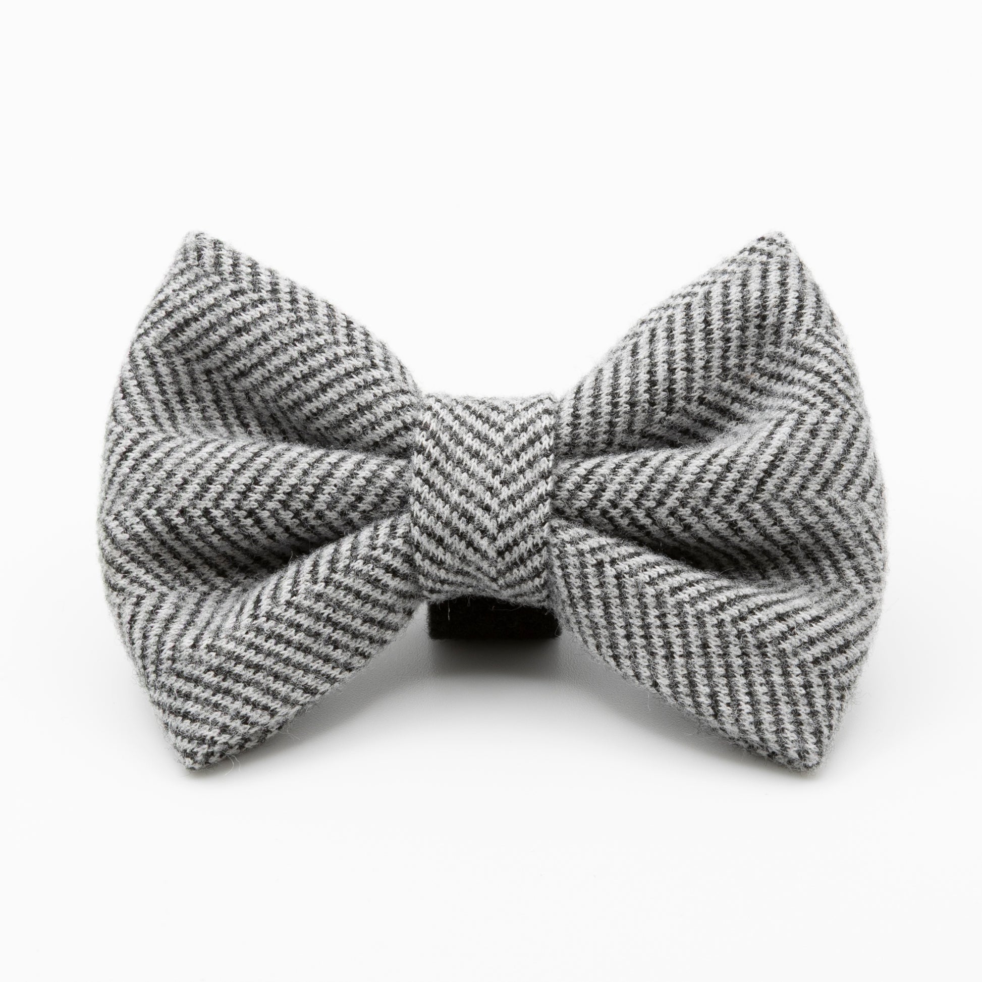The Monochrome Tweed Dog Bow Tie, featuring a gray and white herringbone pattern, is displayed against a plain white background to highlight its classic tweed texture and stylish design.