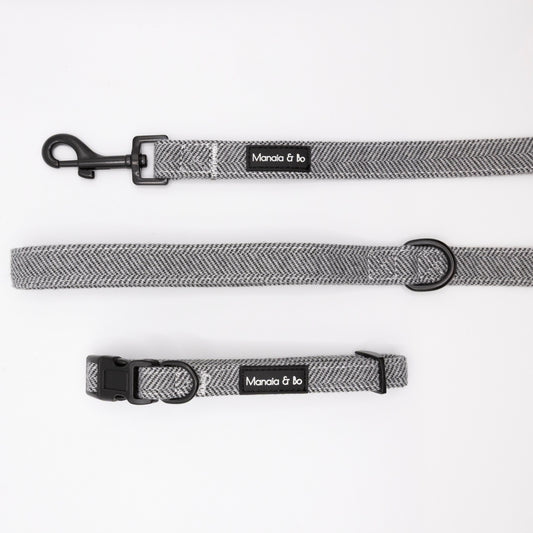 The Monochrome Tweed Collar & Lead, featuring a grey herringbone pattern, black hardware, and a Mania & Ko label, are displayed on a white background.