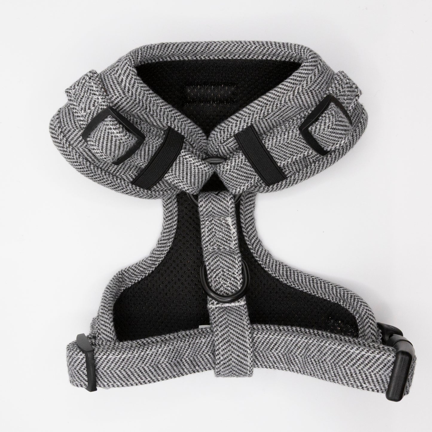 The Monochrome Tweed Harness & Lead, a gray herringbone-patterned adjustable dog harness with black buckles and straps for small to medium dogs, is displayed flat on a white background.