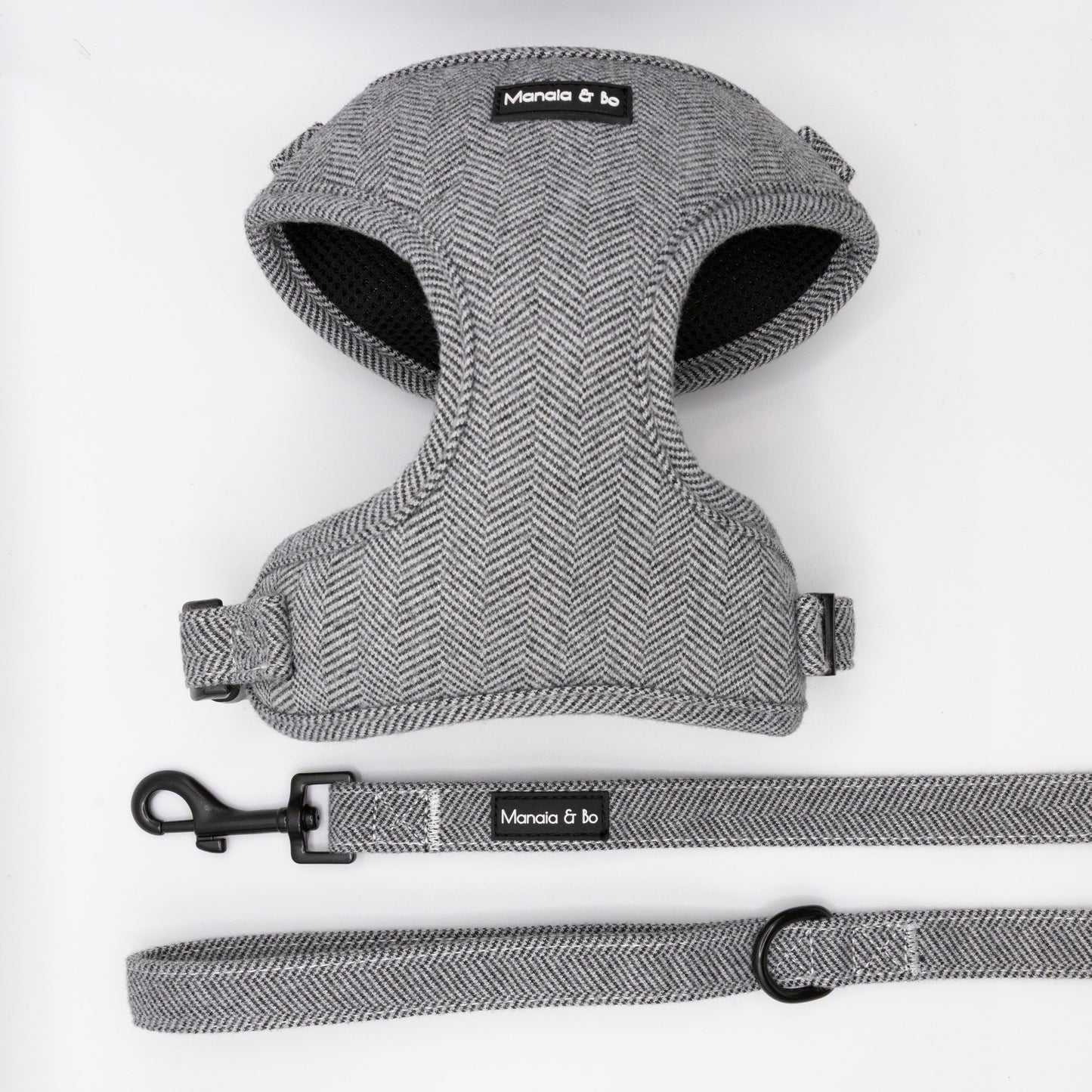 The Monochrome Tweed Harness & Lead features a grey herringbone pattern, black hardware, and Moncia & bo branding. Adjustable and designed for small to medium dogs, it's shown on a white background.