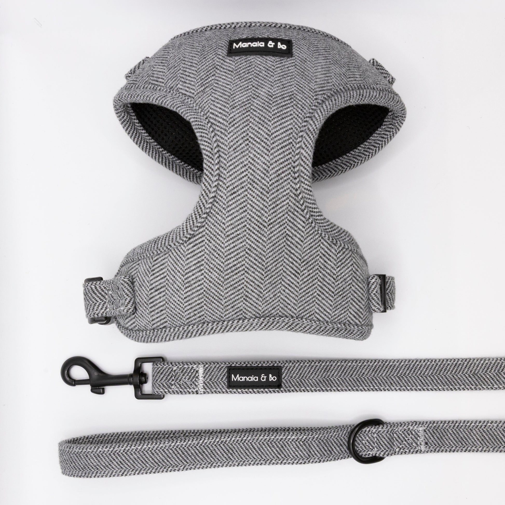 The Monochrome Tweed Harness & Lead features a grey herringbone pattern, black hardware, and Moncia & bo branding. Adjustable and designed for small to medium dogs, it's shown on a white background.