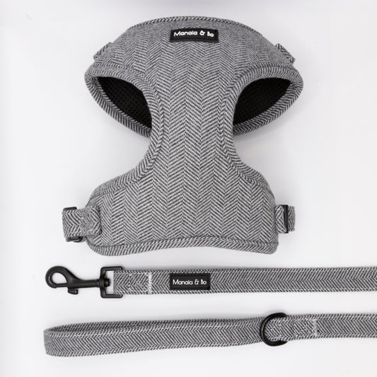 The Monochrome Tweed Harness & Lead features a grey herringbone pattern, black hardware, and Moncia & bo branding. Adjustable and designed for small to medium dogs, it's shown on a white background.