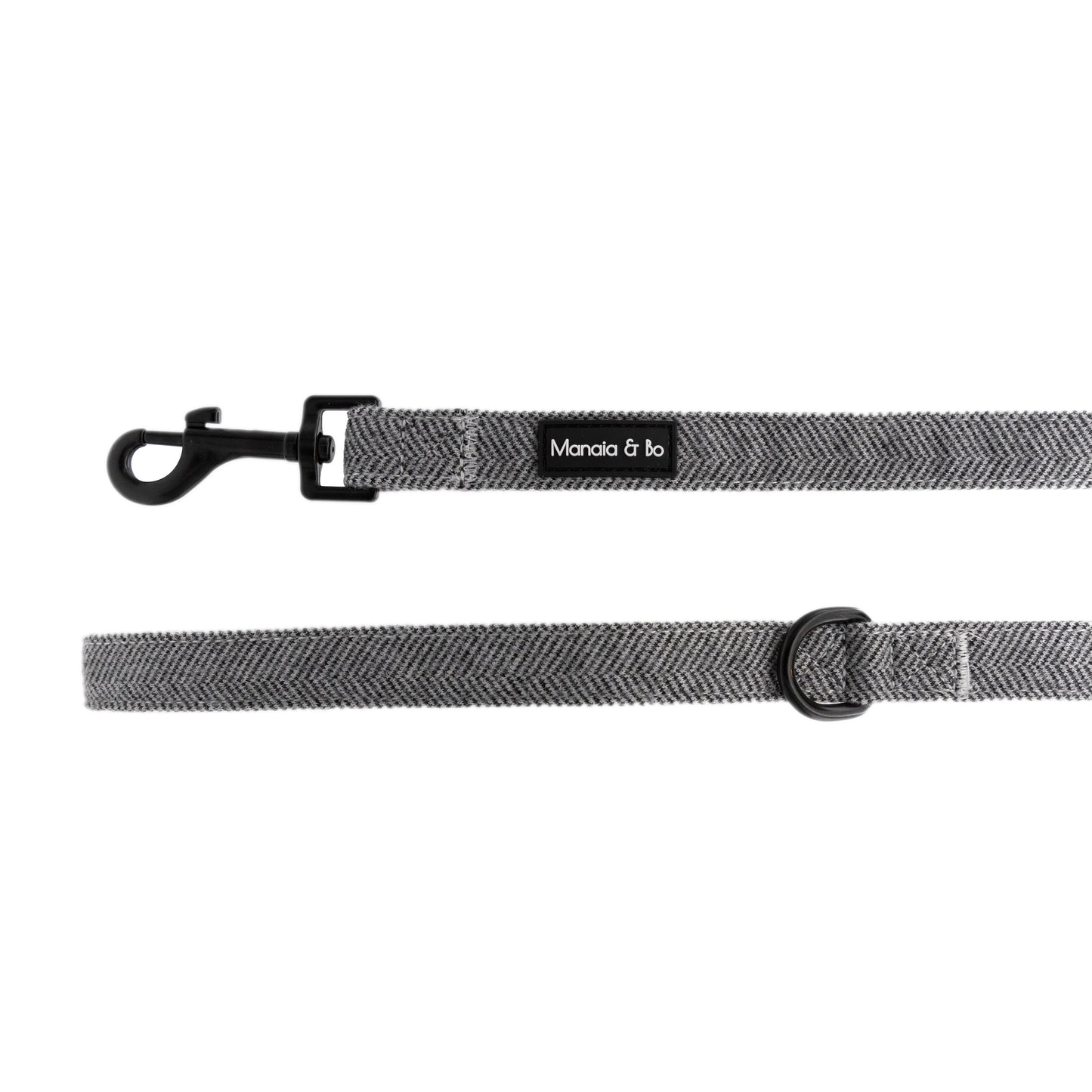 Monochrome (dark grey and white) tweed herringbone lead on a white background from the front showing black metal swivel snap hook and black metal d-ring by the lead handle