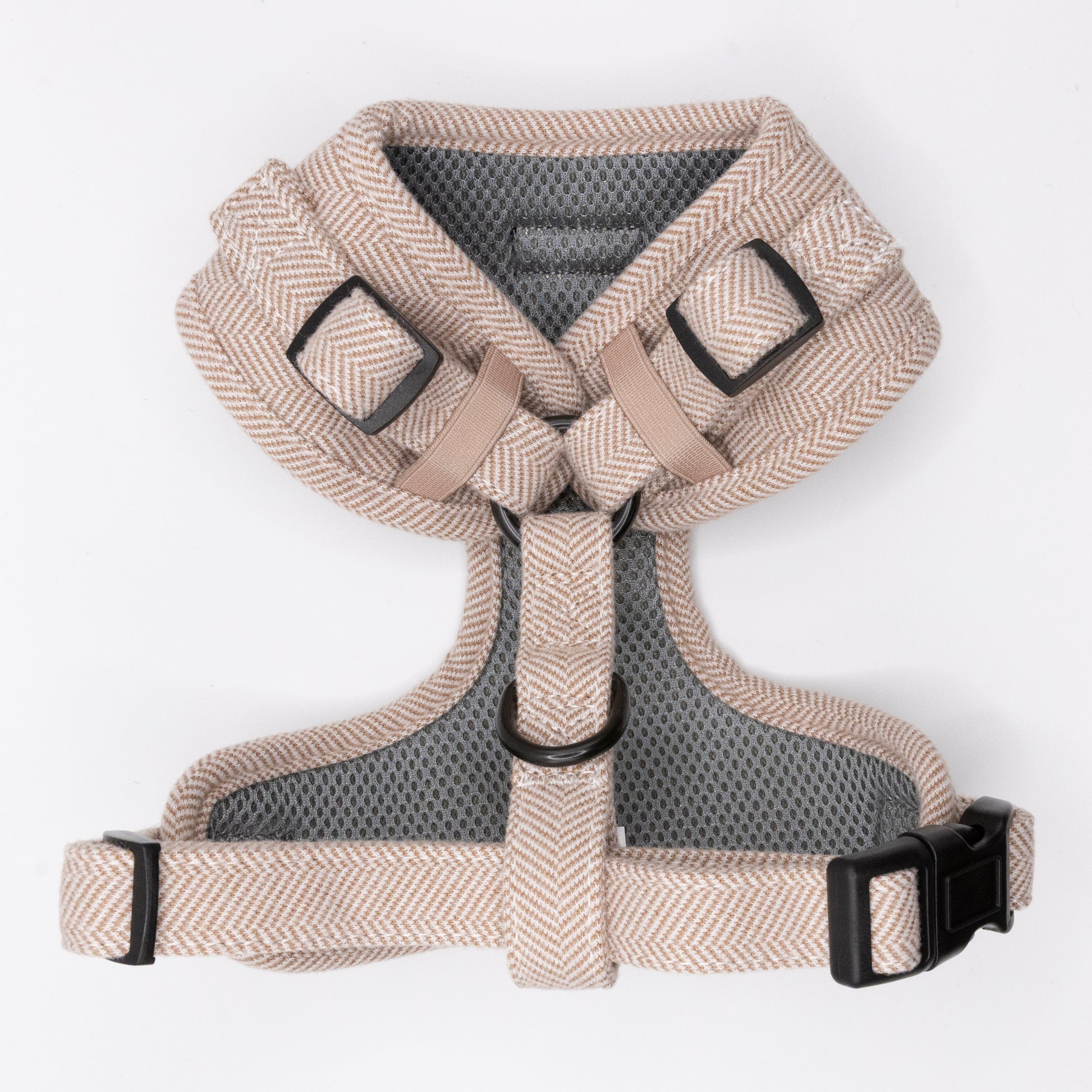 The Nougat tweed Dog Harness is an adjustable beige and gray herringbone-patterned harness with black buckles and a metal D-ring for leash attachment, shown flat on a white background.