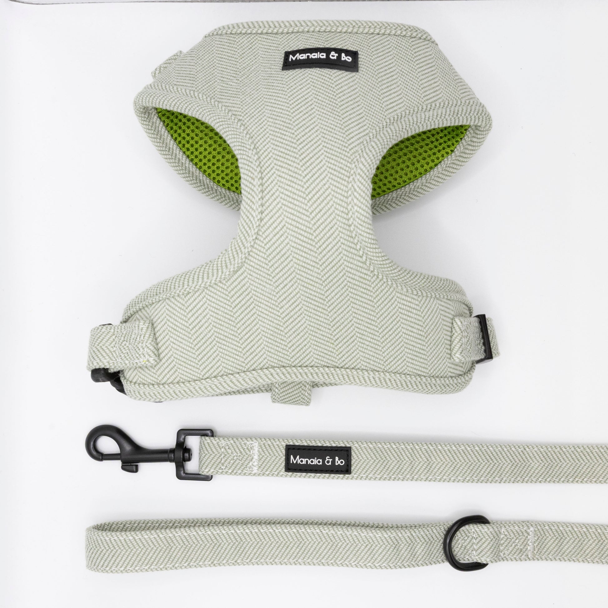 The Pine Tweed Harness & Lead features a light gray tweed dog harness with black buckle, green mesh lining, and a matching leash—both labeled Moncia & bo. The adjustable set is shown on a white background.