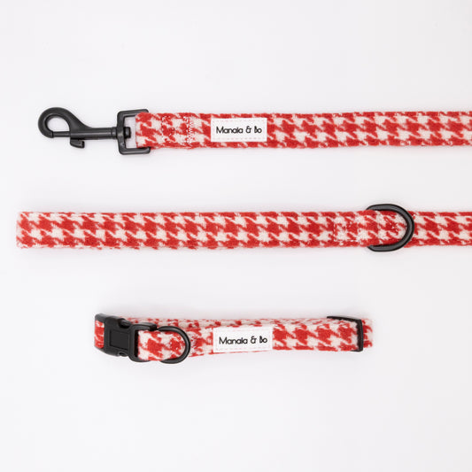 The Scarlet Houndstooth Collar & Lead by Manola & bo includes an adjustable red and white houndstooth dog collar with black buckle and a matching leash, both shown on a white background.