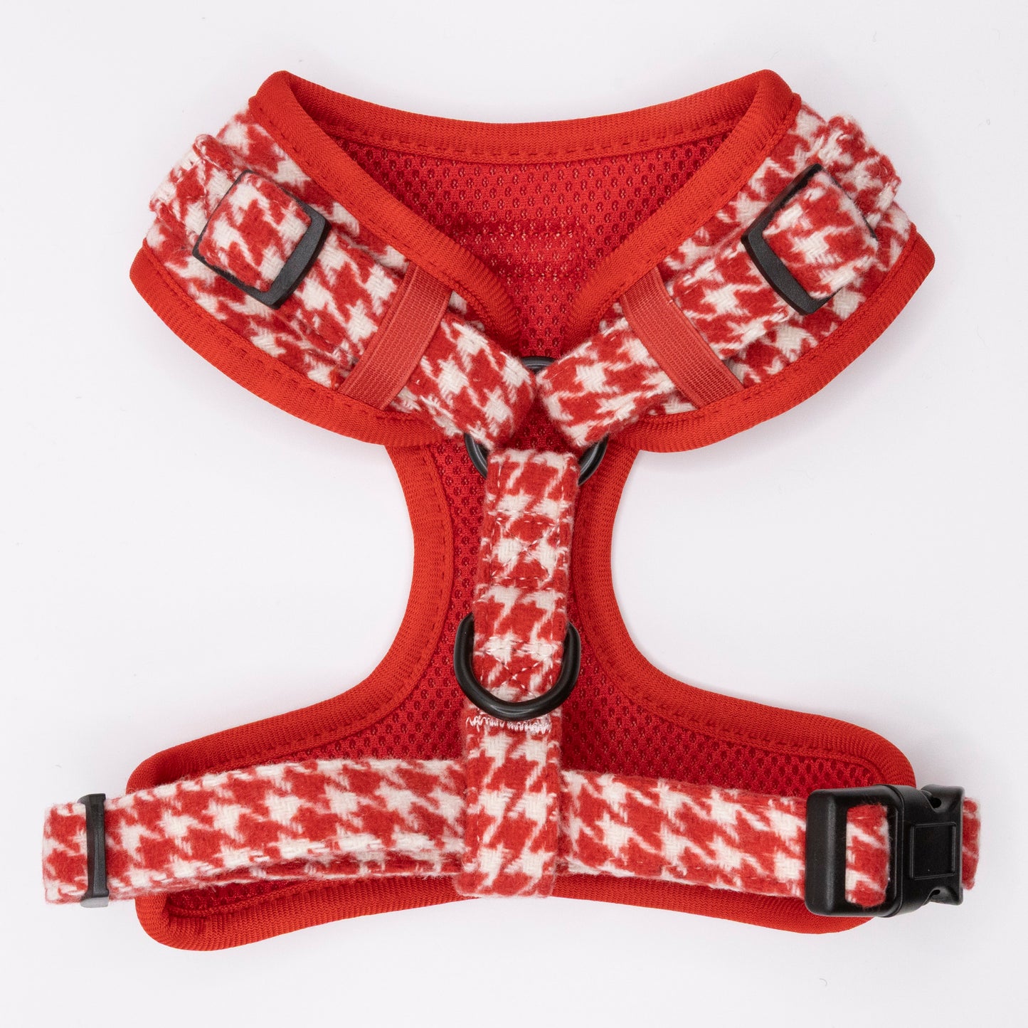 The Scarlet Houndstooth Harness & Lead is a red and white houndstooth-patterned dog harness with black buckles, metal rings, and an adjustable fit, shown laid flat on a white background.
