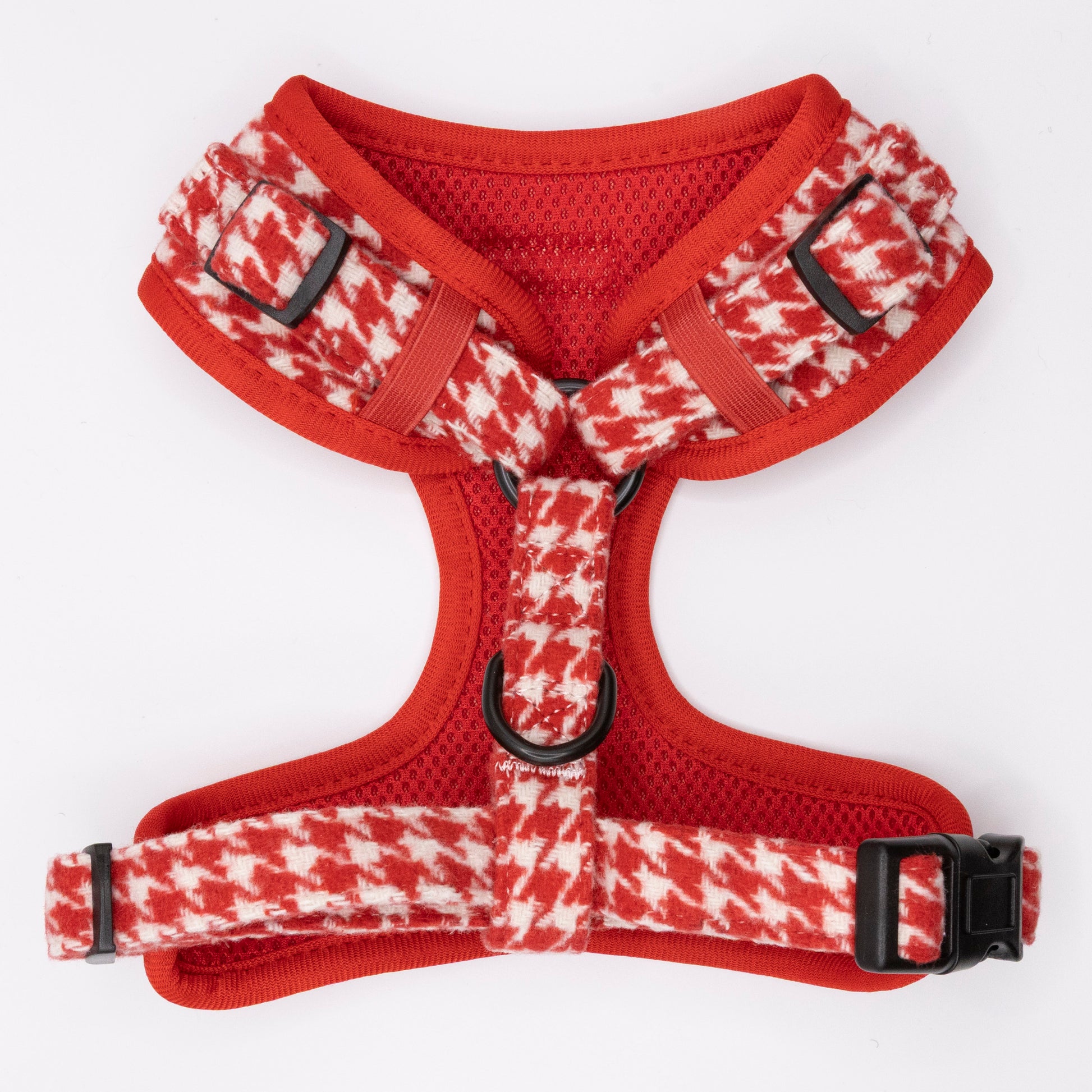 The Scarlet Houndstooth Harness & Lead is a red and white houndstooth-patterned dog harness with black buckles, metal rings, and an adjustable fit, shown laid flat on a white background.