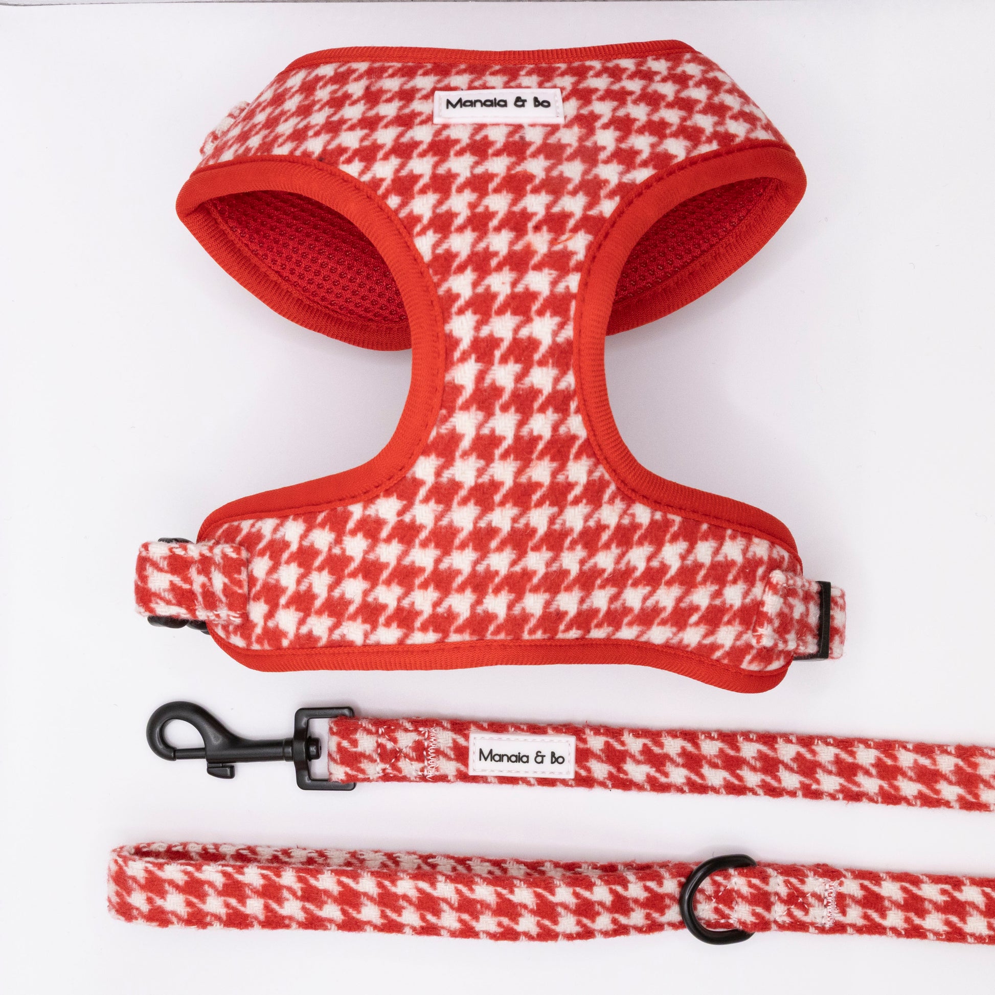 The Scarlet Houndstooth Harness & Lead, featuring a red and white houndstooth pattern and Manolo & co. label, are shown on a white background.