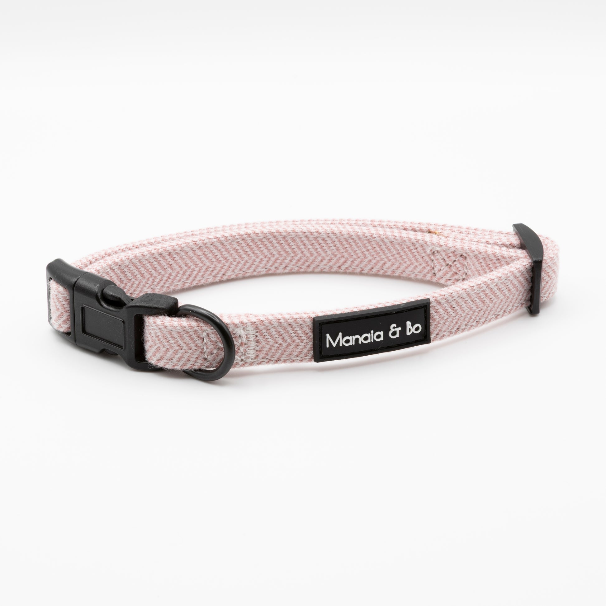 The Tea Rose Tweed Collar & Lead features a light pink herringbone pattern, adjustable black plastic buckle, and a black Manaia & bo name tag, shown on a plain white background.