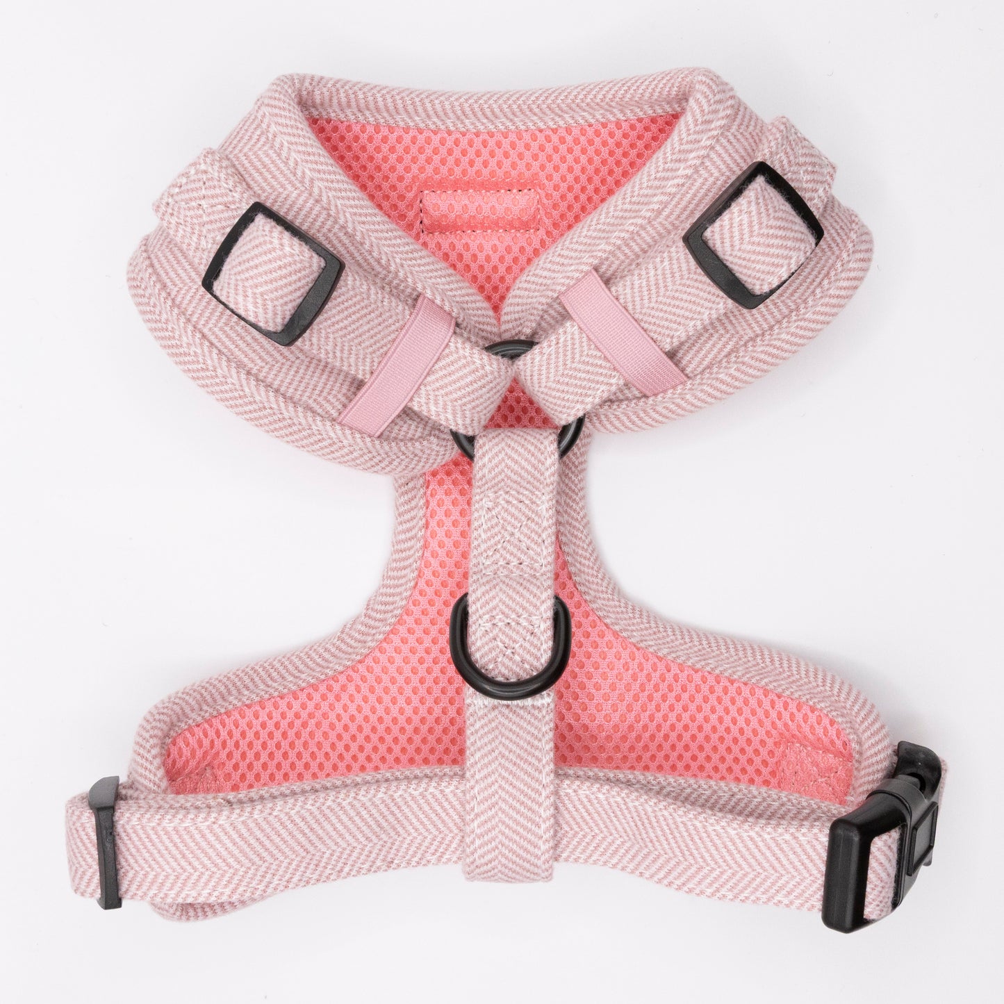 The Tea Rose Tweed Dog Harness is a soft, pink-and-light gray herringbone design with black metal rings and adjustable plastic buckles, shown flat on a white background.