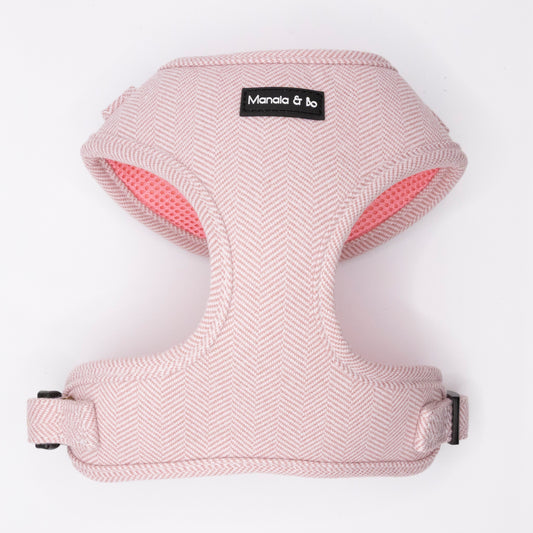 The Tea Rose Tweed Dog Harness features a soft, light pink herringbone pattern and "Manala & bo" label on the front. Adjustable for comfort, it's displayed flat against a white background.