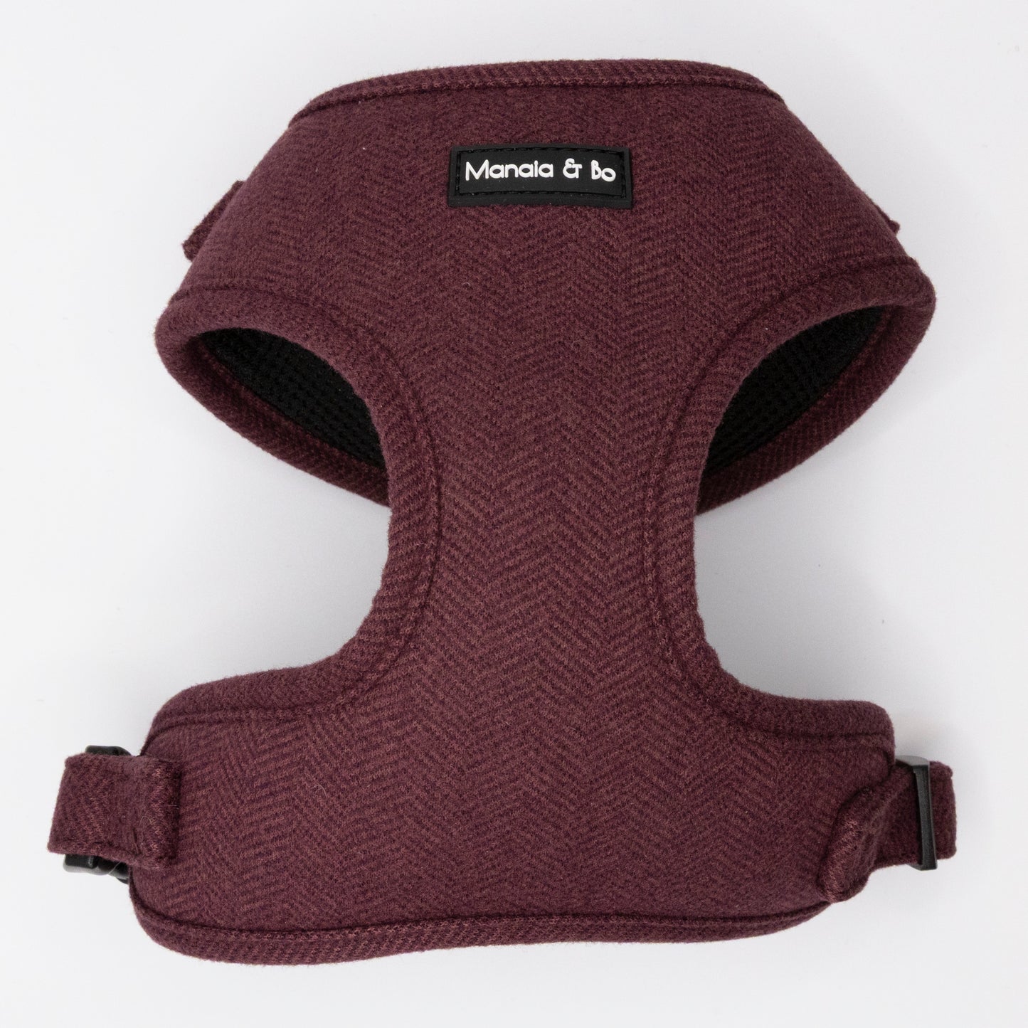 The Wild Plum Tweed Harness & Lead is a maroon adjustable harness with black trim for small to medium dogs. Featuring a "Manala & bo" black label on the front, it’s shown on a plain white background.